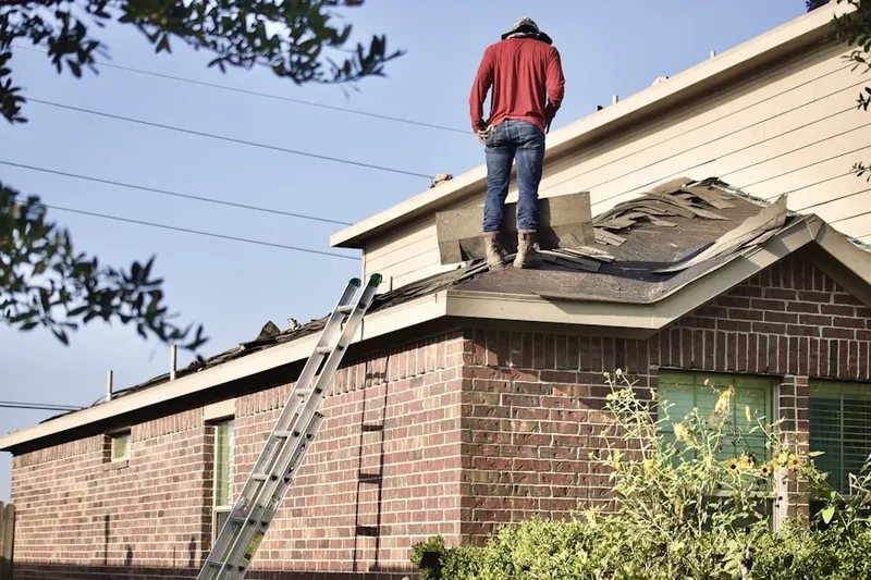 Professional roofer working on a residential roof in Middlegate Village